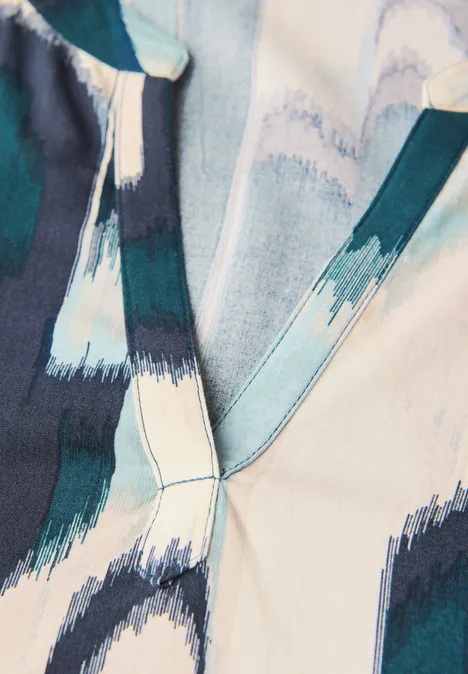 Nahaufnahme eines Stoffes mit blau-weißem Muster und V-Ausschnitt.